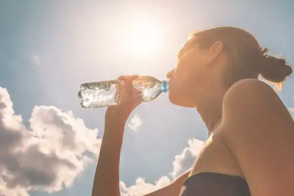 Hydration: The Secret Ingredient for a Toned Stomach and Enhanced Fitness 3 Image of woman drinking water to hydrate East Kilbride after run.